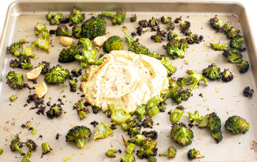 Broccoli and boursin cheese on a sheet pan after being roasted. 
