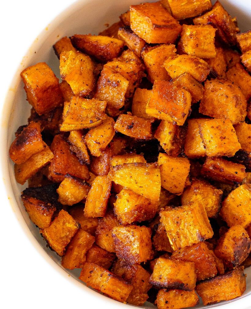 Roasted sweet potatoes served in a large white bowl.