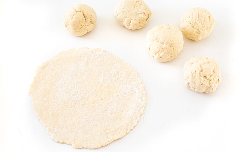 A piece of naan dough rolled into a circle.