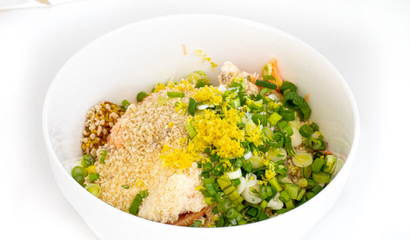 Ingredients for salmon cakes in a white mixing bowl.
