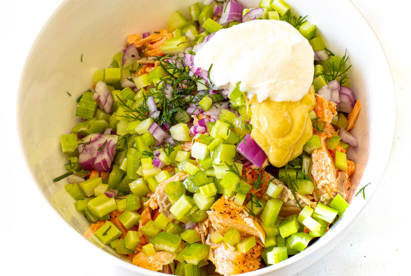 Ingredients for salmon salad in a bowl before being mixed. 