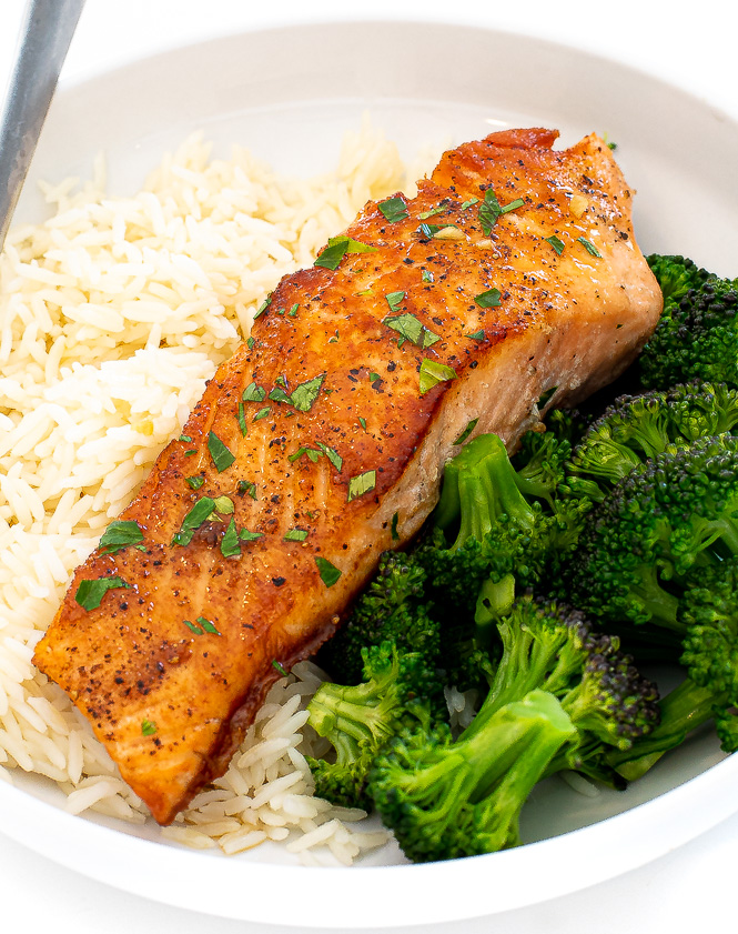 salmon in white bowl with rice and steamed broccoli