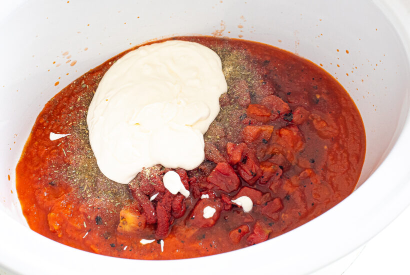 Ingredients for tomato sauce in a slow cooker before being mixed together.