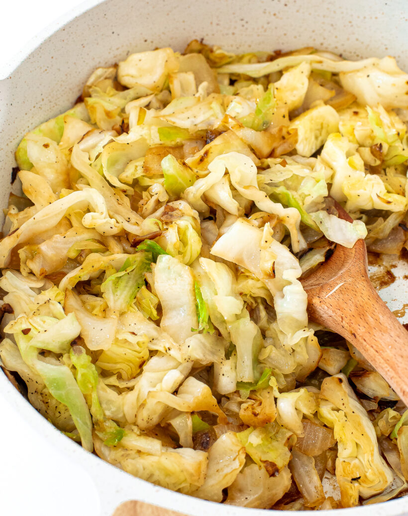 Cabbage and onions in a skillet after being sautéed. 