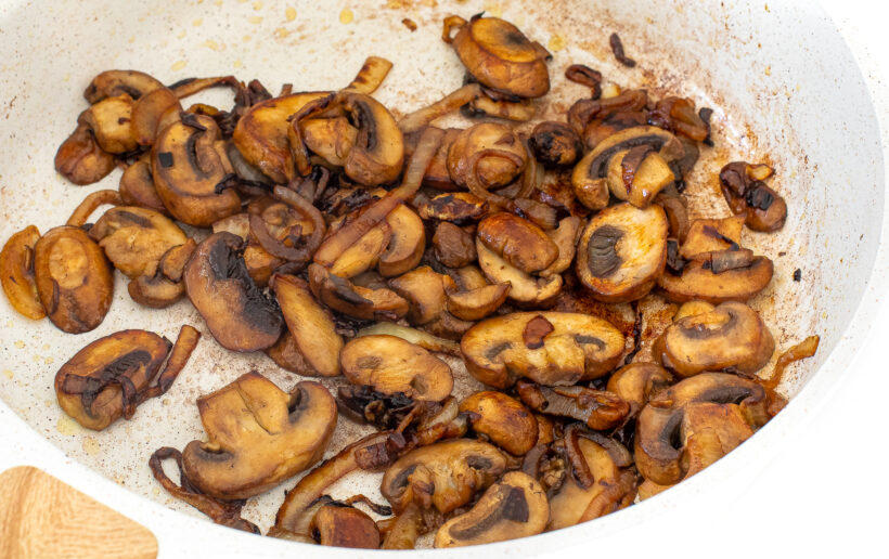 Mushrooms in a white frying pan.