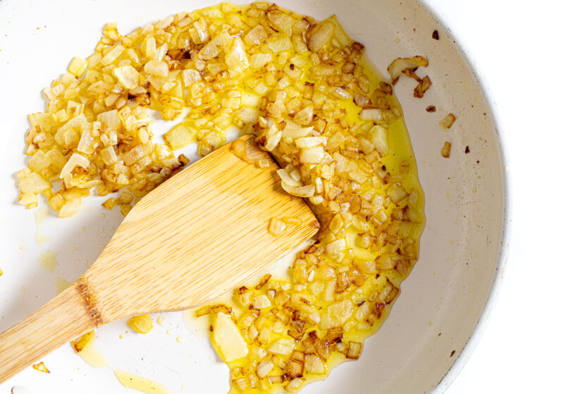 Onions sautéing in a skillet with olive oil. 