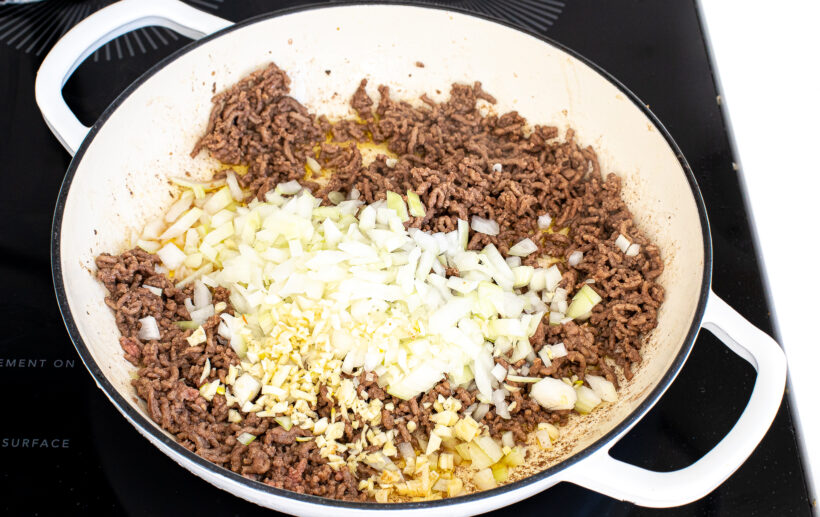 Ground beef, onion, and garlic in a large white skillet.