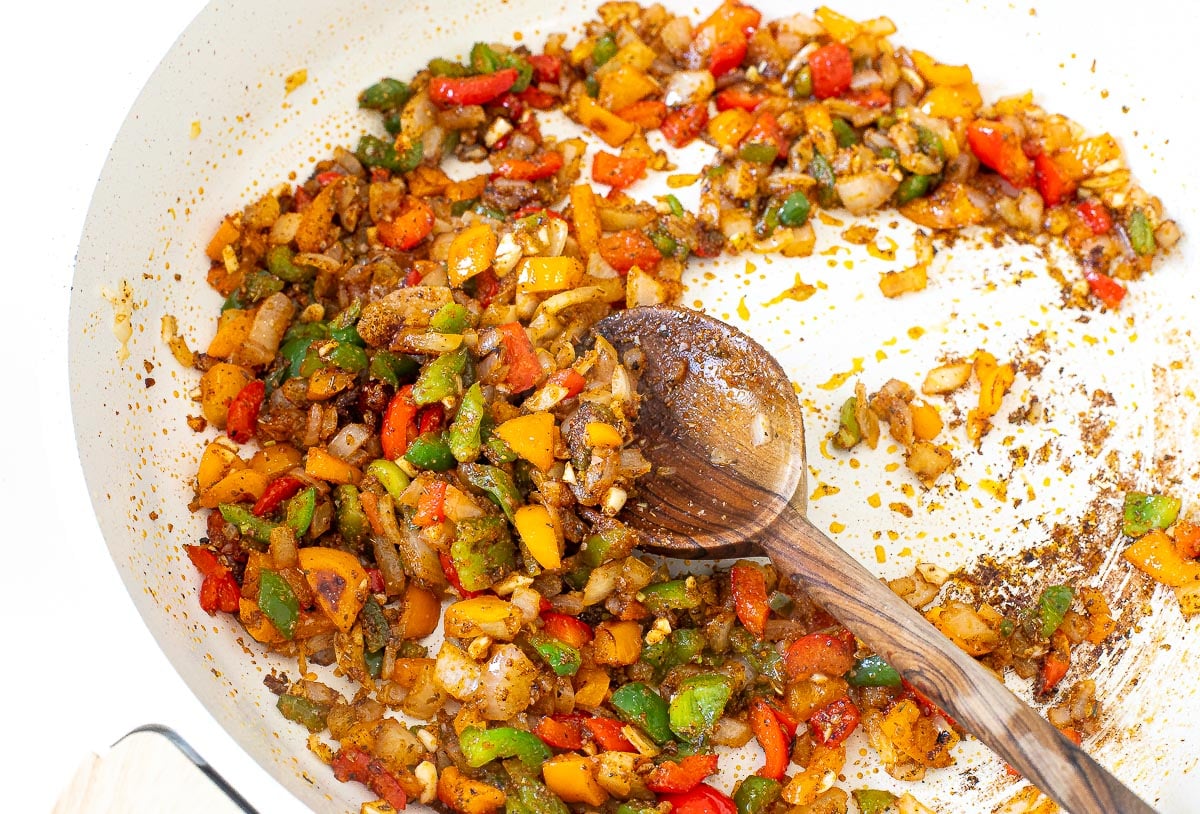 sautéed bell peppers and onions in large skillet with seasonings