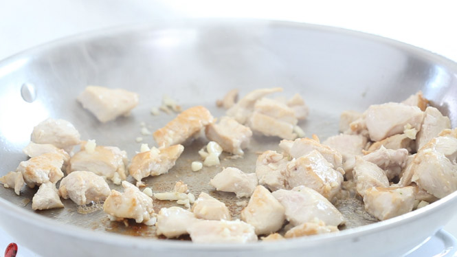 sautéing chicken and garlic in skillet
