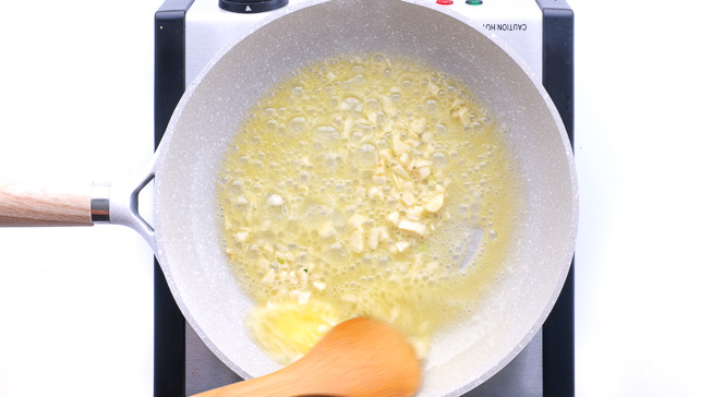 cooking minced garlic in melted butter in skillet