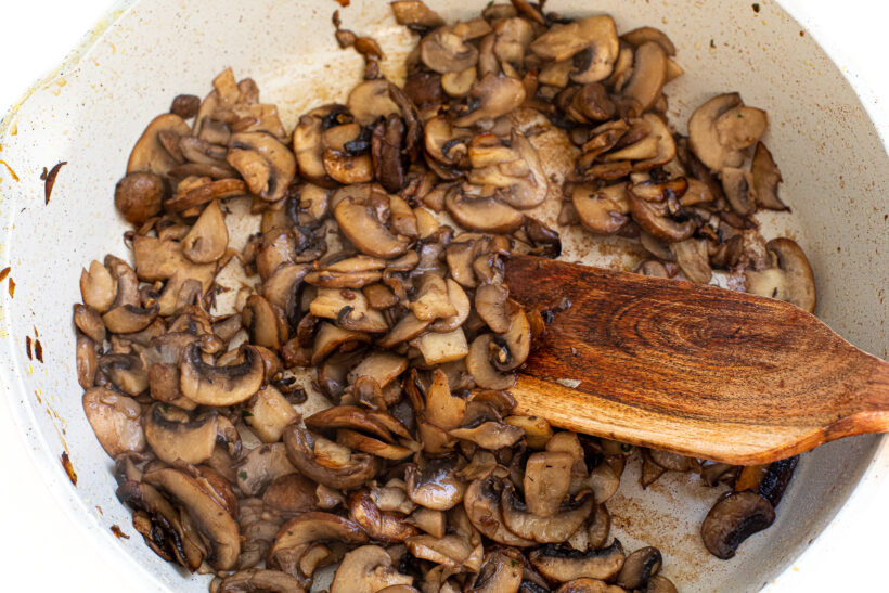 Mushrooms sauteeing in a skillet.
