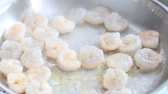 Sautéing shrimp in large skillet.