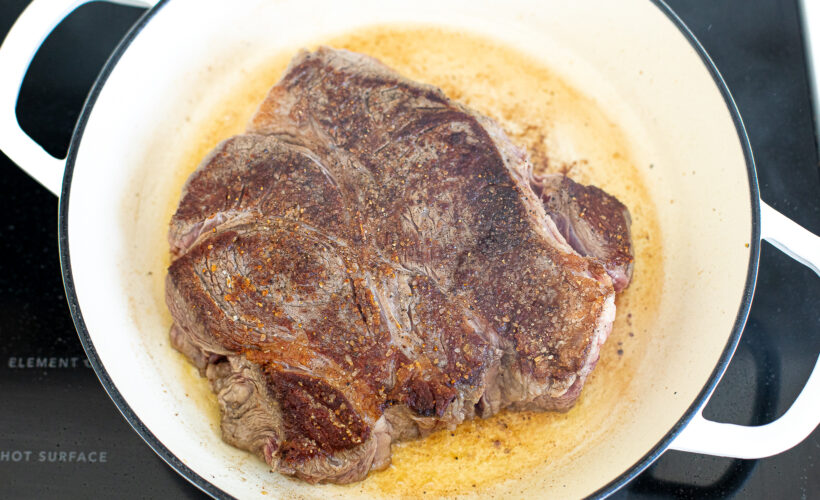 Chuck roast browned in a skillet.