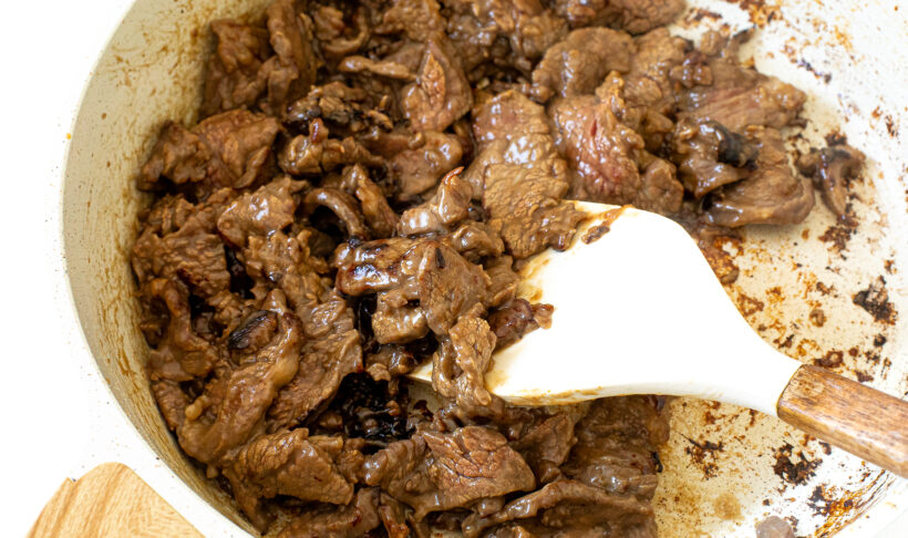 searing flank steak in a large skillet