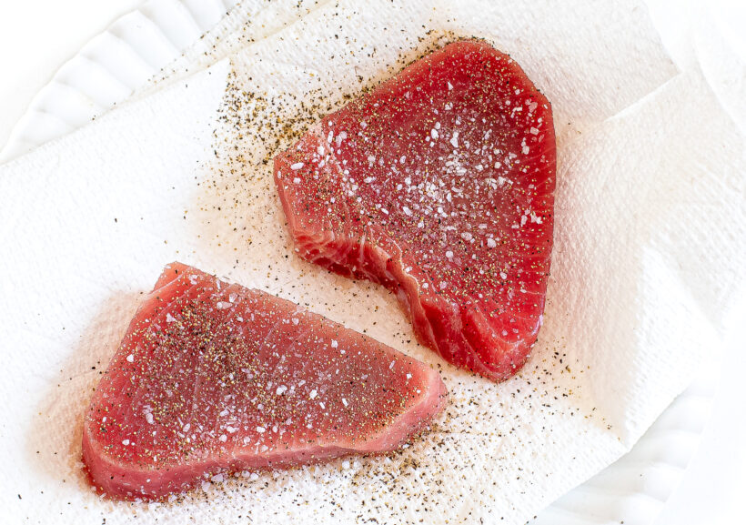 Raw tuna filets seasoned with salt and pepper.