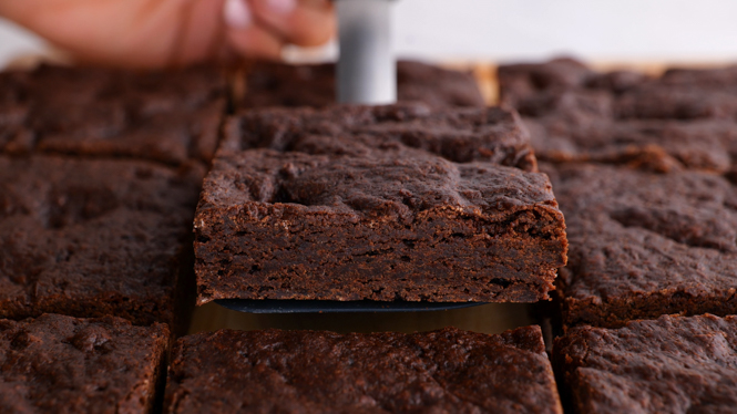 A spatula holding a sliced brownie.