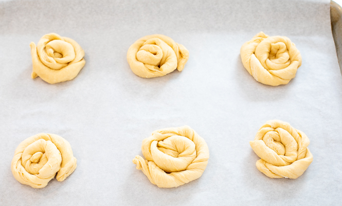 Crescent roll dough formed into circular danishes on a baking sheet. 