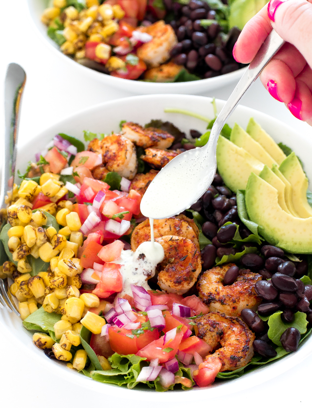 drizzling honey jalapeno dressing onto avocado shrimp salad