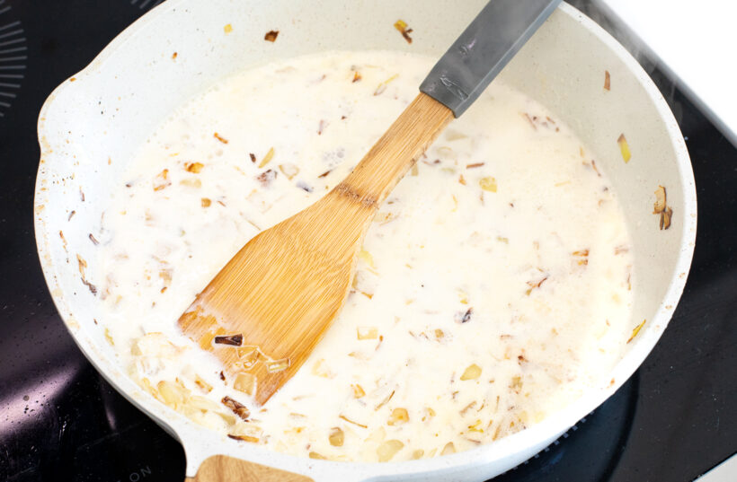 Gorgonzola cream sauce in a skillet with onions and garlic.