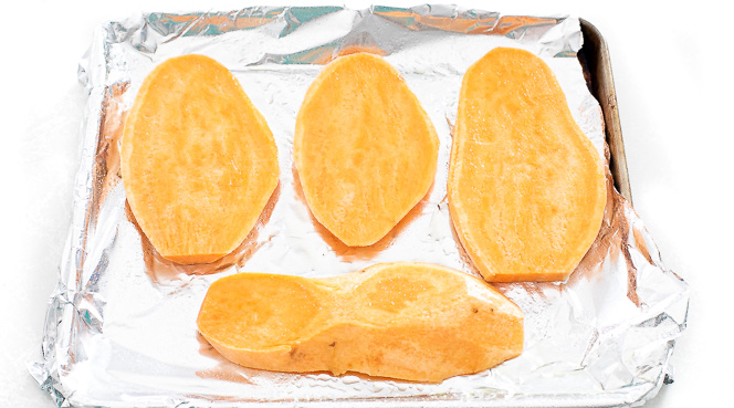 Sweet potato slices on a baking sheet lined with foil.