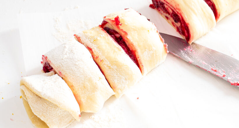 Cranberry rolls being sliced.