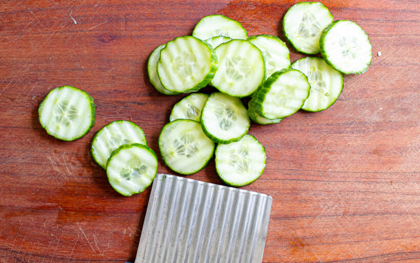 Sliced pickles on a cutting board.