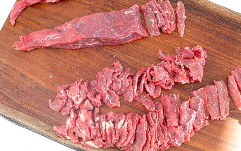 Sliced flank steak on a cutting board.