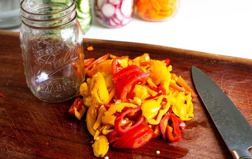 Chopped vegetables on a cutting board with a knife.