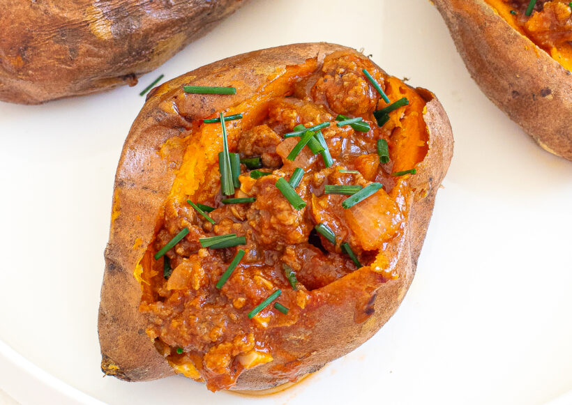 Sweet potato served with sloppy joe mixture and chives on top.