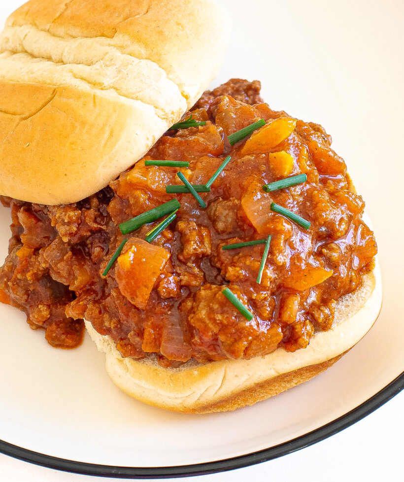 Open faced sloppy joe on a white plate. 