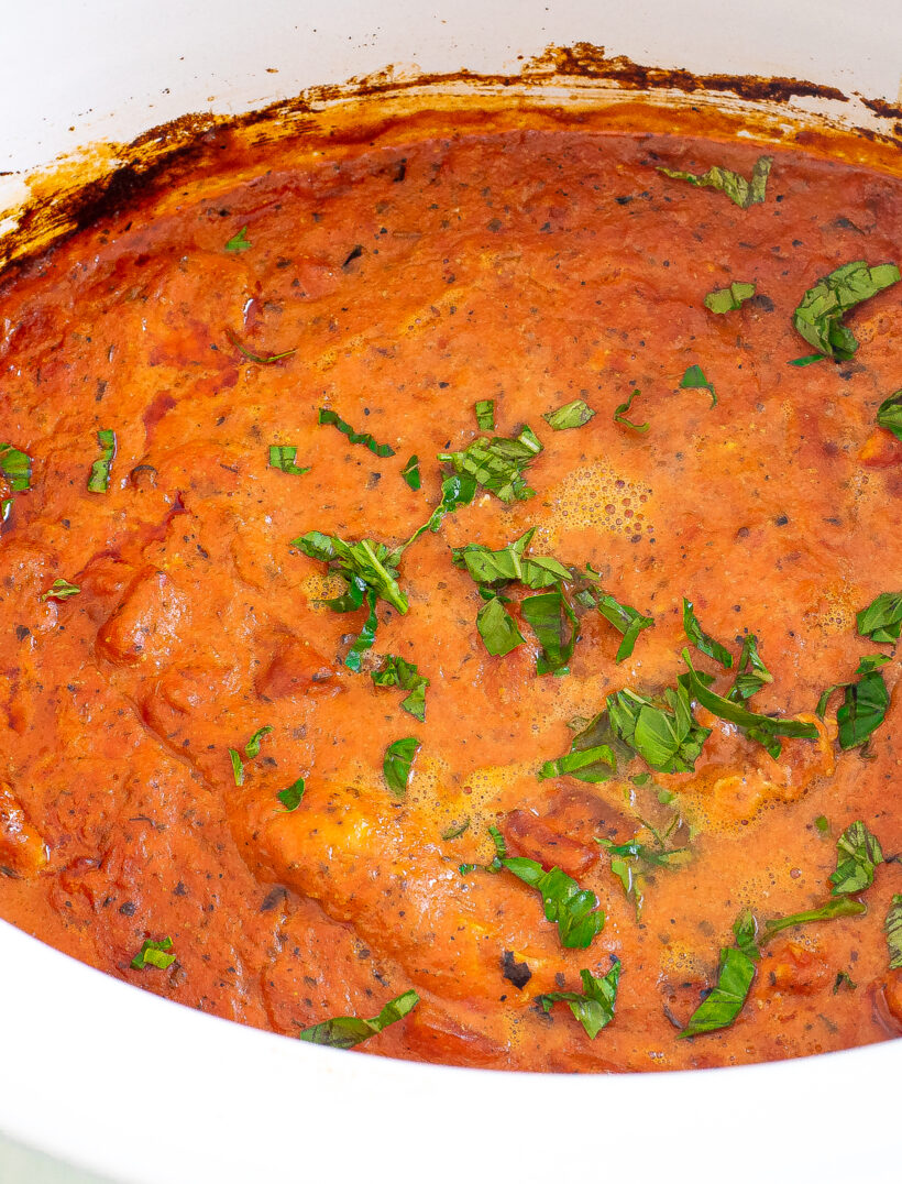 Basil sprinkled on top of the tomato sauce and chicken in the crockpot.