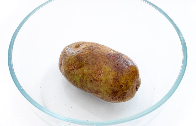 Potato in a bowl with salt and water. 