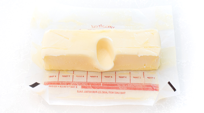 softened butter with a finger print in it to show it is at the perfect temperature