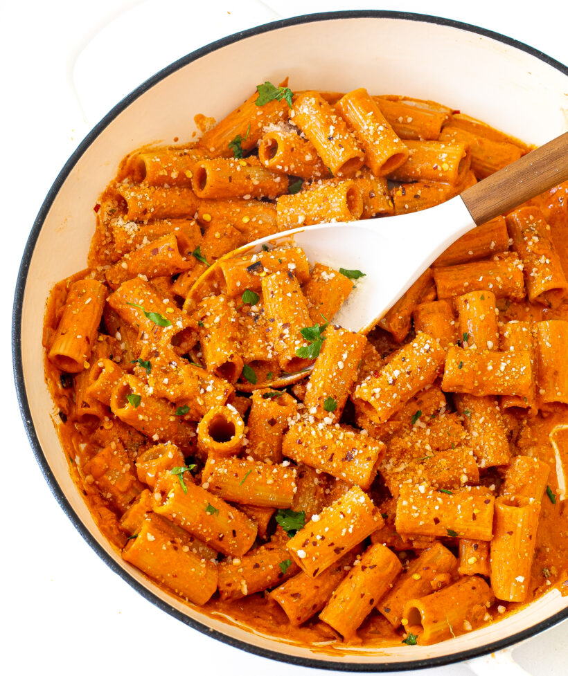 Overhead shot of Calabrian chili pasta in a skillet topped with parmesan and red pepper flakes. 