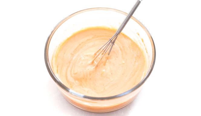 The spicy mayo recipe is ready in a small bowl with a whisk.