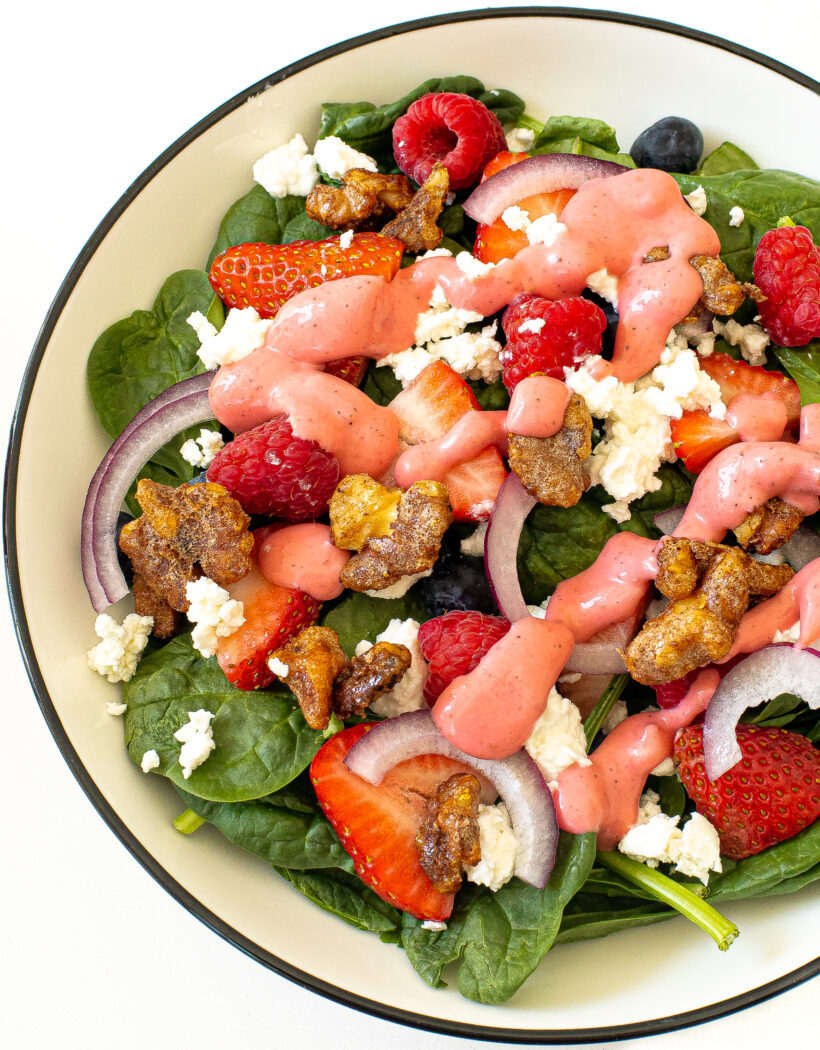 Spinach salad topped with candied walnuts.