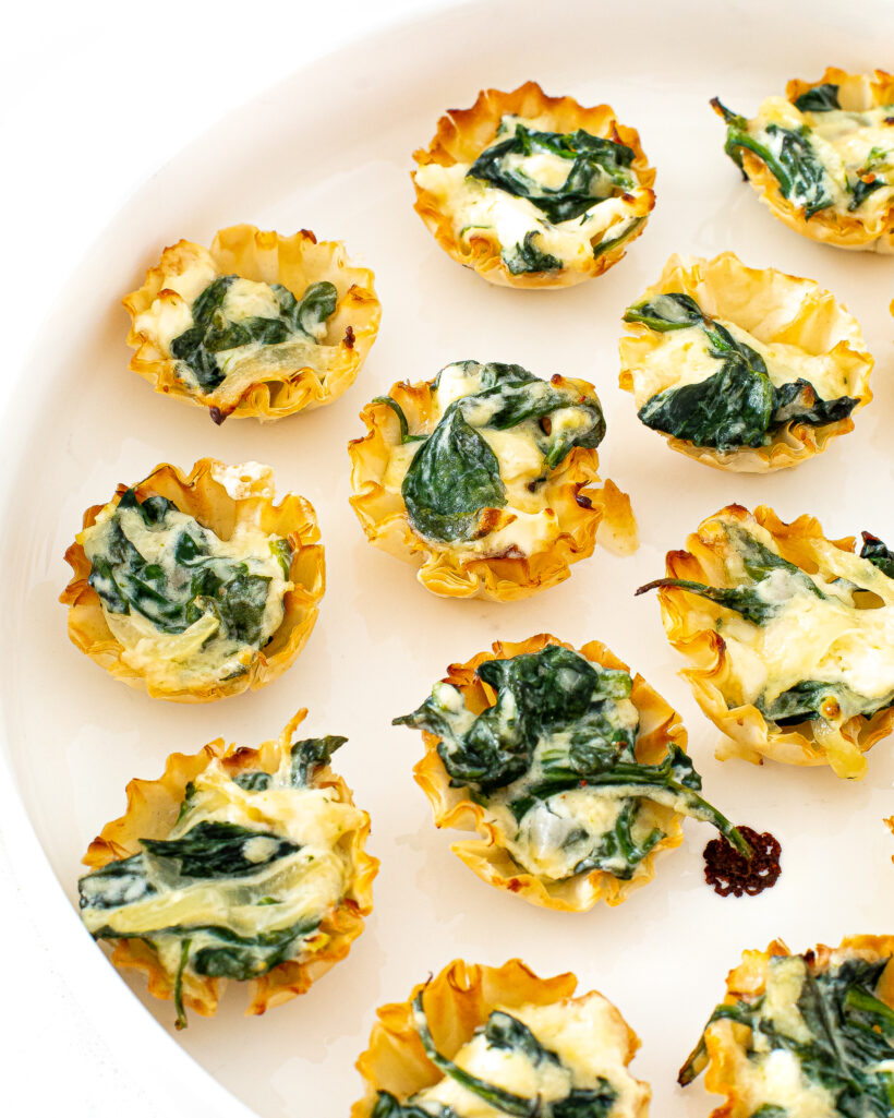 Spinach Phyllo Cups placed on a white serving plate.