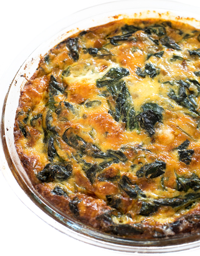 Spinach Crustless Quiche in a clear glass pie dish.