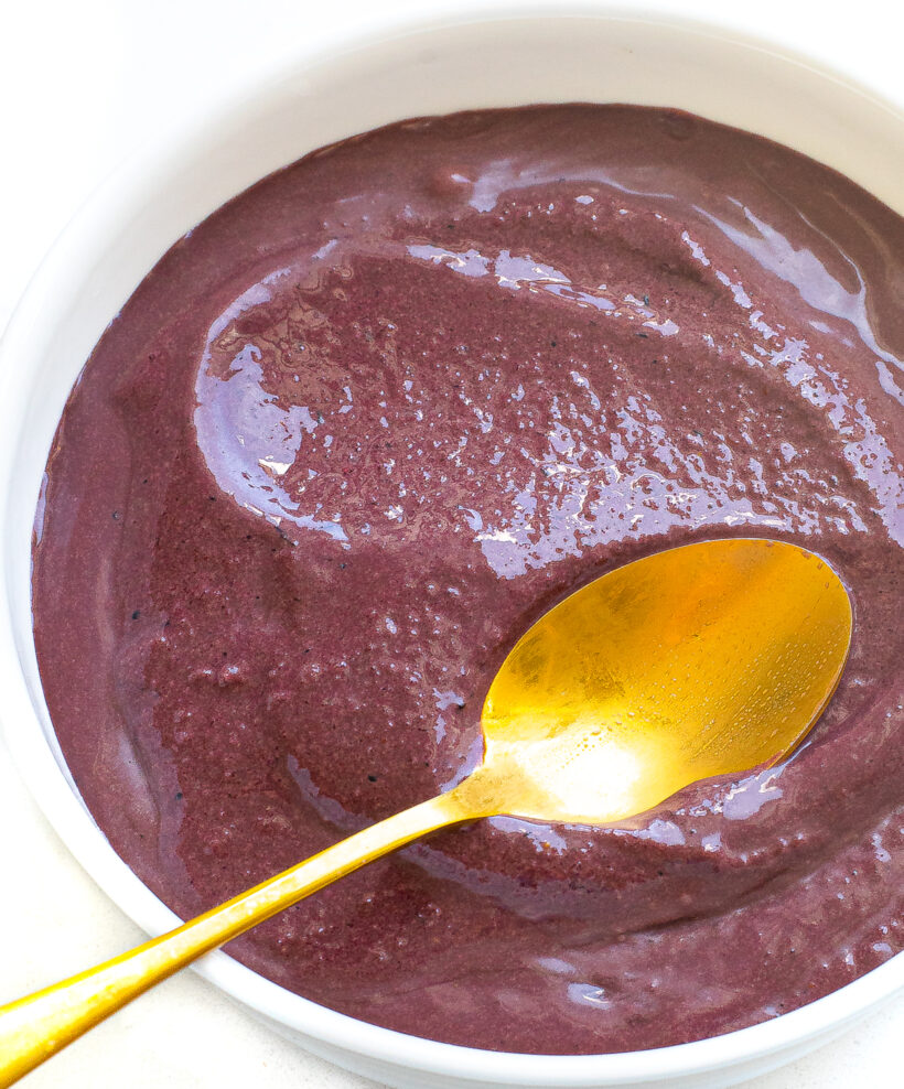Purple acai bowl base in a bowl with a golden spoon. 