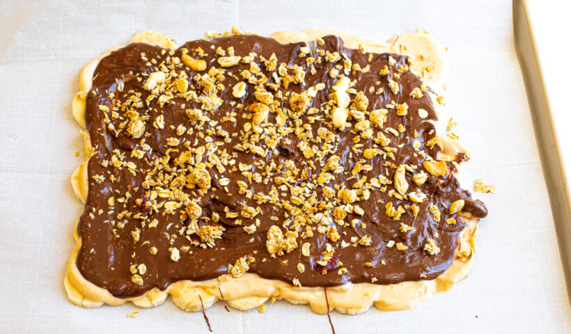 Melted chocolate on top of the other layers, with granola sprinkled on top. 