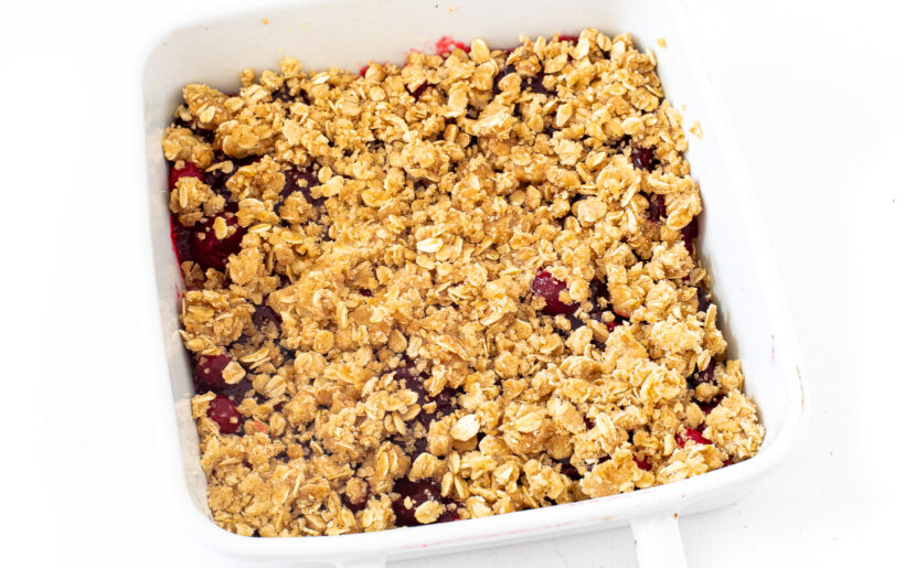 Unbaked cranberry crumb bars in a white baking dish.
