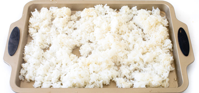Rice in a layer on a sheet pan.