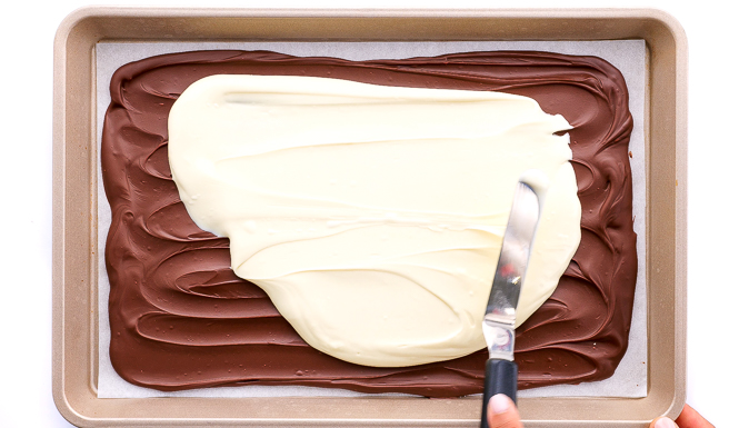 spreading melted white chocolate on top of semi sweet chocolate