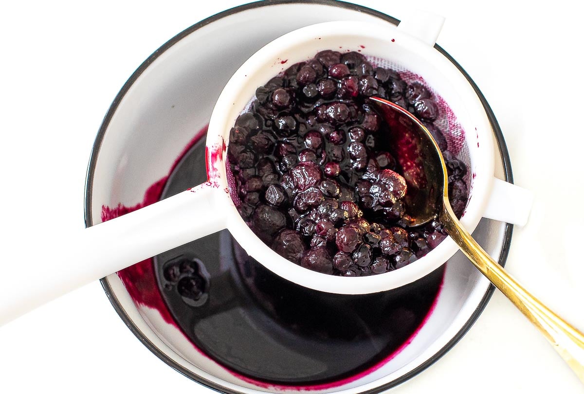 straining blueberries into a puree