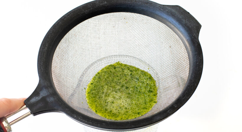 Straining the lemonade through a sieve.