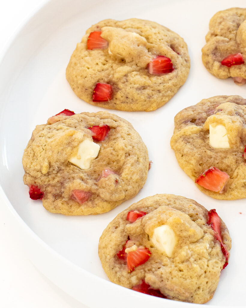 Strawberry cookies lined up on a white serving tray.