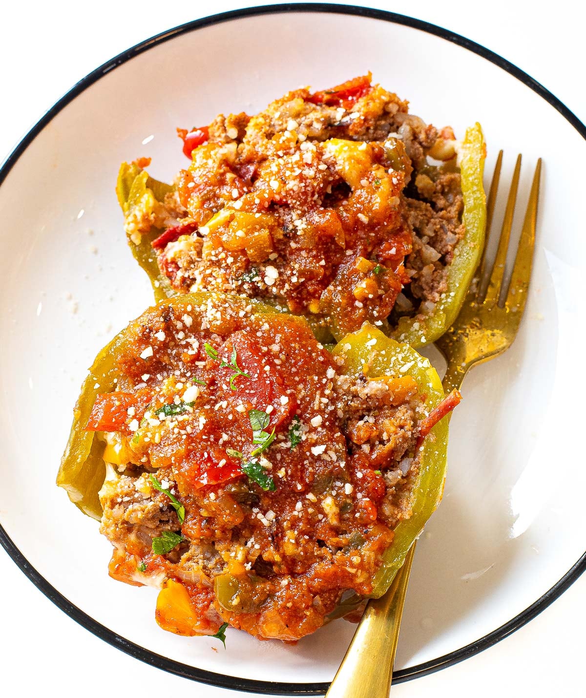 stuffed peppers cut in half sprinkled with parmesan cheese on a plate