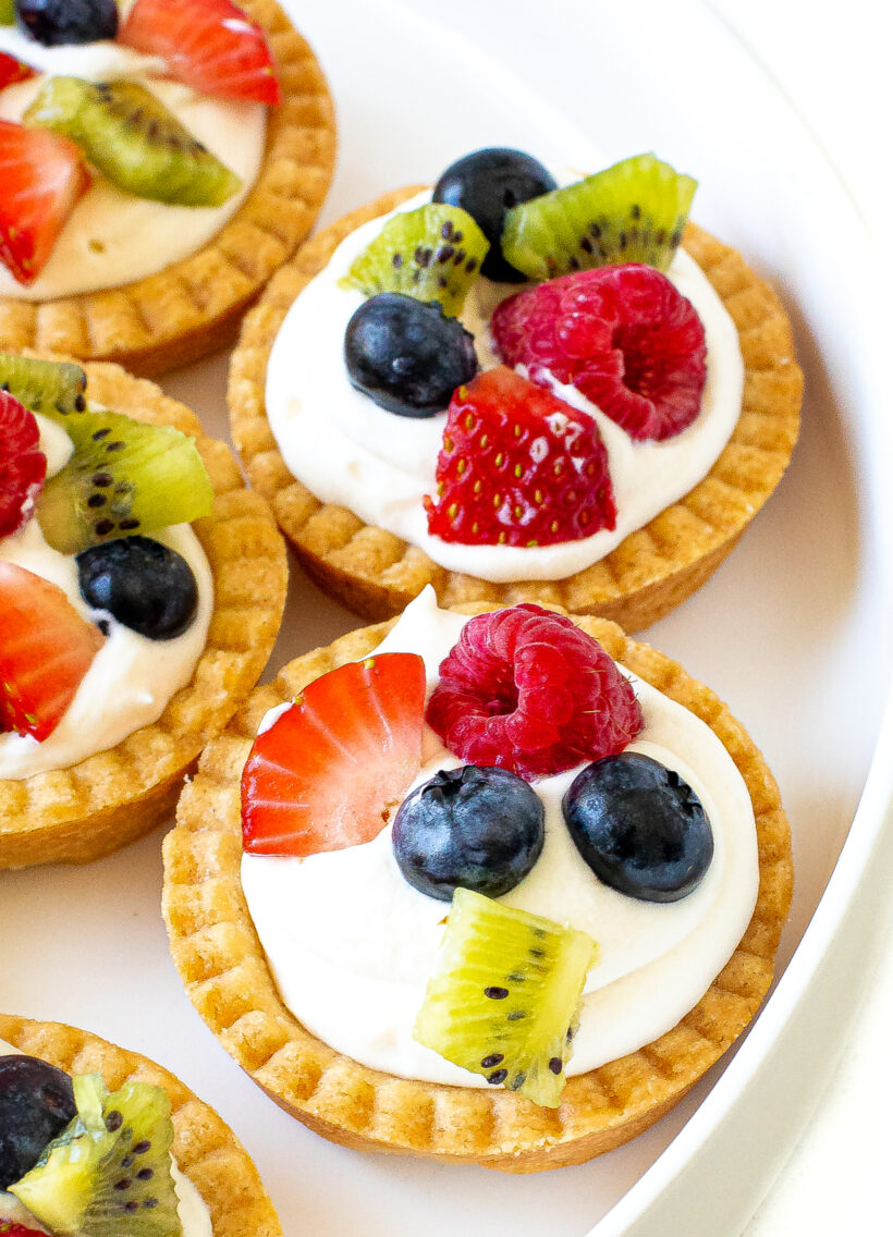 Mini fruit tarts topped with fresh fruit.