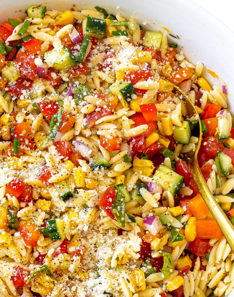 Summer orzo pasta salad topped with parmesan cheese. 
