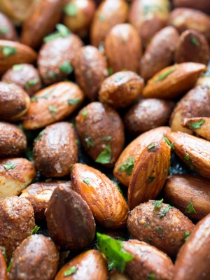 close up shot of spicy almonds with cilantro flakes